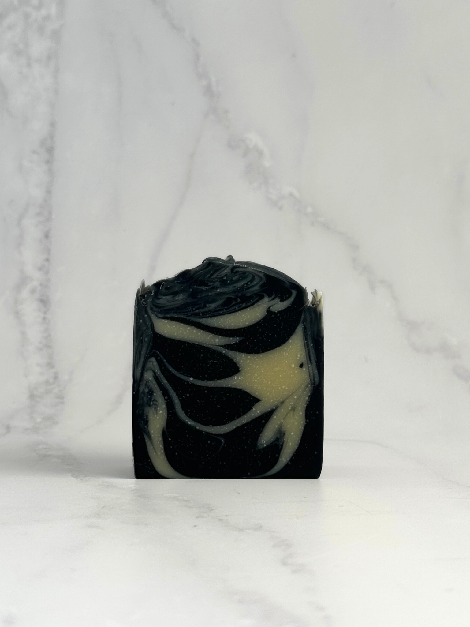 Detox Bar by Dew Kind – hand-crafted in Aotearoa with BioGro-certified organic tallow, activated charcoal, and kaolin clay, black and white marbled bar on marble background