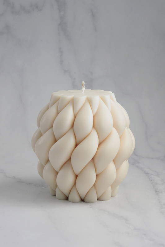 Hand-poured Tapestry Candle with a woven design, made from natural soy wax and displayed as a decorative piece.
